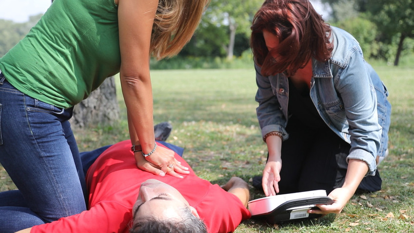 Richtiges Handeln bei einem Notfall rettet Leben - © Österreichisches Rotes Kreuz (ÖRK) / Markus Hechenberger Ersthelferin führt Herzdruckmassage aus, eine zweite Helferin bereitet den Defibrillator vor.