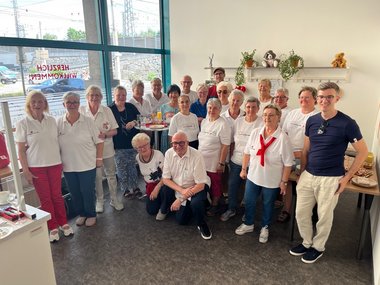 Gruppenfoto aller freiwilligen Mitarbeiter:innen im Rotkreuzmarkt für Bekleidung in Linz