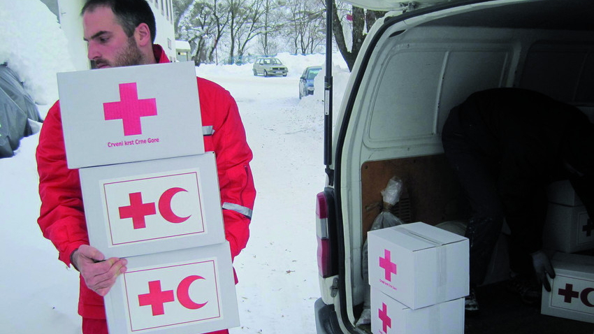 © Österreichisches Rotes Kreuz (ÖRK) / Montenegrinisches Rotes Kreuz Montenegro. Februar 2012. Ein Rotkreuzhelfer lädt Hilfsgüter aus einem Transporter. Im Hintergrund tiefer Schnee