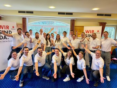 Gruppenaufnahme der Teilnehmerinnen und Trainerinnen des Jugendrotkreuz-Workshops. Sie tragen alle weiße Rotkreuz-Polos.