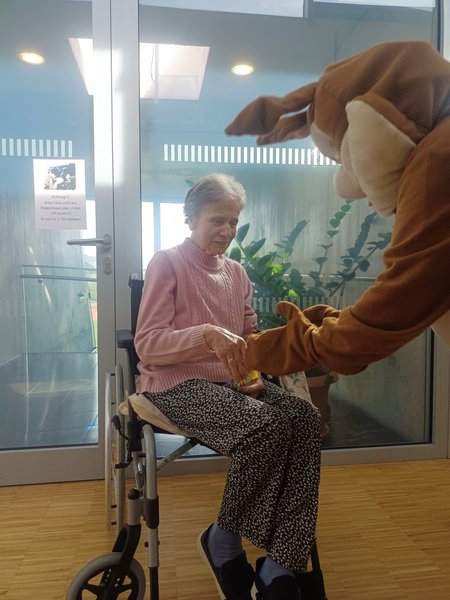 Der Osterhase übergibt einer Bewohnerin Geschenke