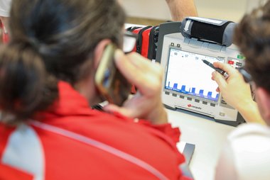 Ein Notarzt erklärt einem anderen Notarzt die Anzeige auf einem Corpuls-Bildschirm.