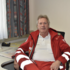 Christian Lamisch sitzt in Rotkreuz-Uniform in einem Büro und blickt in die Kamera.
