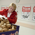 Auf dem Bild eine Dame die eine große Menge Brot in von einem Sackerl in eine Kiste leert