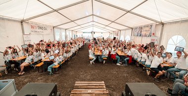 Alle Teilnehmer:innen des Jugendrotkreuz-Landesbewerbs in einem großen Zelt, alle mit Tablets in der Hand.