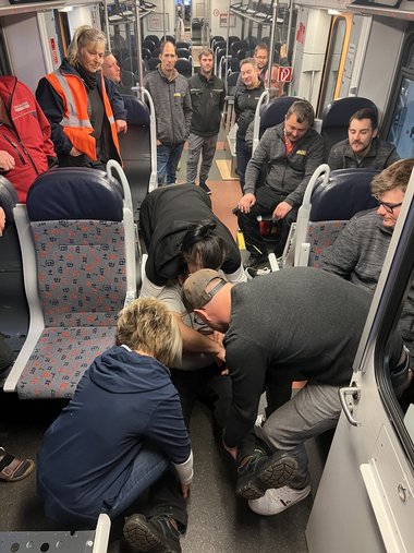 Erste-Hilfe-Szene in einem Bahnwaggon mit Mitarbeitern Stern & Hafferl