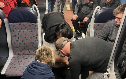Erste-Hilfe-Szene in einem Bahnwaggon mit Mitarbeitern Stern & Hafferl