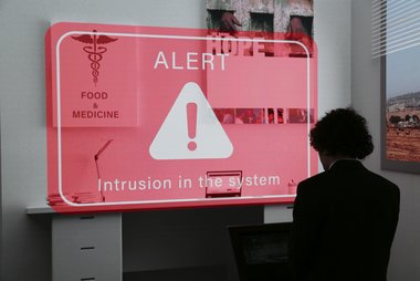 Digitales Bild mit roter ALERT Warnung, eine Person steht davor
