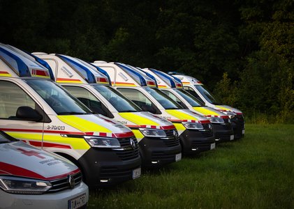 Rotkreuzautos stehen nebeneinander auf einer Wiese anlässlich des Waidhofner Volksfestes 2025.