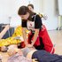 Ein Kinder übt die Reanimation an einer Puppe.