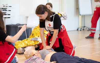 Ein Kinder übt die Reanimation an einer Puppe.