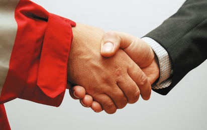 © Österreichisches Rotes Kreuz (ÖRK) / LV OÖ / Asanger Handshake, Bildausschnitt. 1 Hand in Rotkreuz-Uniform, 1 Hand mit Hemd / Anzug. Querformat.