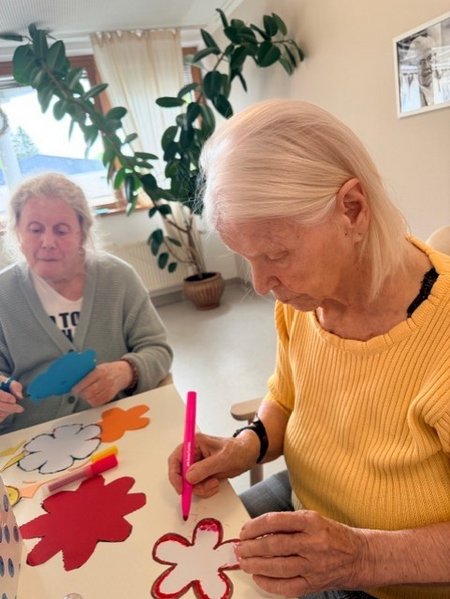 Bewohnerinnen des Seniorenwohnhauses helfen bei der Gestaltung der Wände mit.