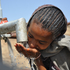 Ein Kind in Afrika labt sich am Wasserhahn. Trinkwasser für die Ärmsten der Armen