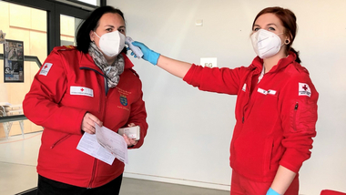 Bezirksstellenkommandantin Katrin Wiesinger bei der Fiebermessung vor der Blutspende mit Rotkreuz-Sanitäterin Vanessa Hufnagl.
