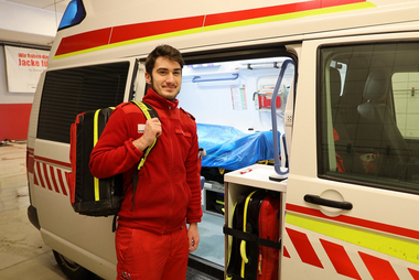 Zivildiener Lukas Wirth vor Rettungswagen auf der Dienststelle Eferding