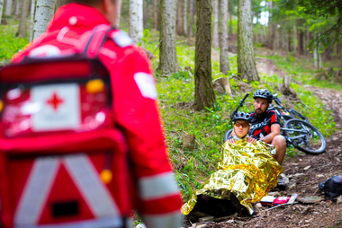 Ein Sanitäter kommt zu einem Mountainbikesturz