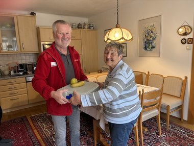 Übergabe Mittagessen von Essen auf Rädern-Mitarbeiteer an Klientin