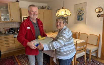 Übergabe Mittagessen von Essen auf Rädern-Mitarbeiteer an Klientin