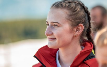 Nachhaltigkeit im Roten Kreuz - © Rotes Kreuz Tirol, Berhard Stolz eine junge Frau in roter Uniform blickt in die Ferne und hat einen sehr zufriedenen, aber auch nachdenklichen Blick