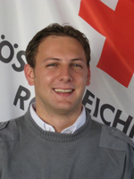 FGG6: DI(FH) Stefan Paier - © Rotes Kreuz Knittelfeld FGG6 - DI(FH) Stefan Paier - in Rotkreuz-Uniform vor einer Rotkreuz-Standarte.
