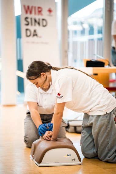 Jugendliche üben die Wiederbelebung an einer Übungspuppe