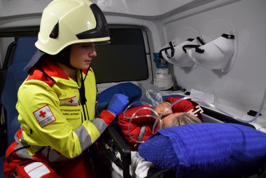 Eine Sanitäterin betreut eine verletzte Person im Rettungswagen