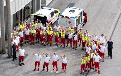 Ein Gruppenfoto mit im Kreis stehenden Rotkreuz-Helferinnen