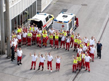Ein Gruppenfoto mit im Kreis stehenden Rotkreuz-Helferinnen