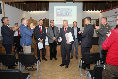 Leopold Hartl mit der Verdienstmedaille in Gold vor den Gästen der Bezirksstellenversammlung des Roten Kreuzes Urfahr-Umgebung