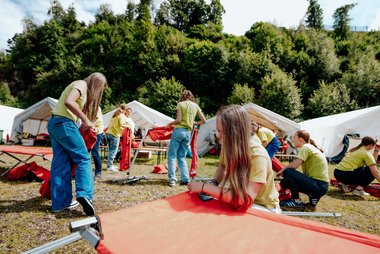 Jugendliche beim Aufbauen der Feldbetten am Landesjugendcamp des Jugendrotkreuzes
