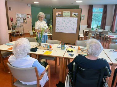 Workshop-Leiterin erarbeitet mit einer Pinnwand Begriffe für einen Schreib-Workshop.