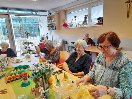 Bewohner:innen und Besucher:innen dekorieren gemeinsam Ostereier