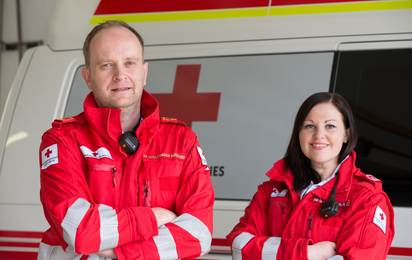 Mann und Frau in roter Rot-Kreuz-Jacke