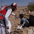 Ein Bub bekommt Wasser von Mitarbeiter:innen des Afghanischen Roten Halbmondes