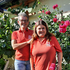 Zwei Rotkreuzmitarbeiterinnen stehen vor einem Blumenstrauch