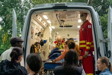 Besucherinnen eines Kinderfestes blicken von außen in die Kidsambulanz