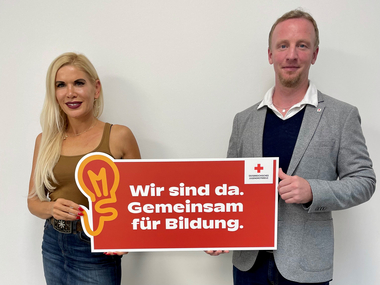 Stürzer und Kaineder halten das Schild zur Initiative "Gemeinsam für Bildung"