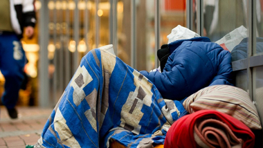 Ein Mensch auf der Straße, mit seinen wenigen Habseligkeiten. Dieser Mensch hat kein zuhause und lebt auf der Straße