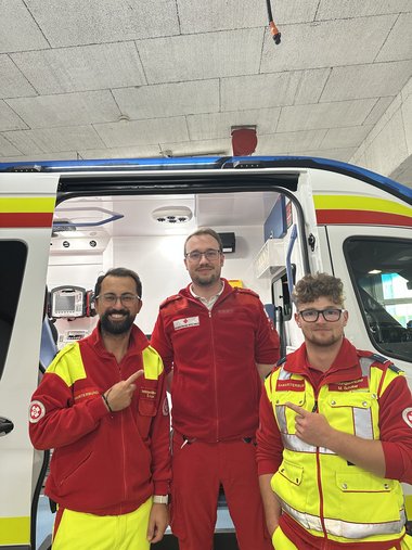 Drei Sanitäter vor Rettungsauto