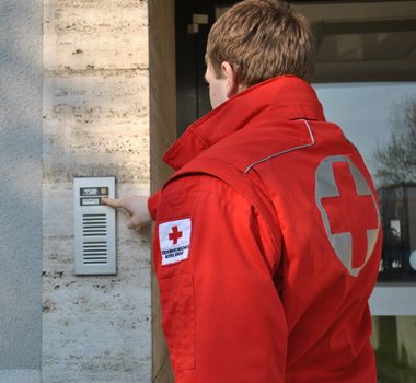 Rotkreuz-Mitarbeiter läutet bei der Haustüre