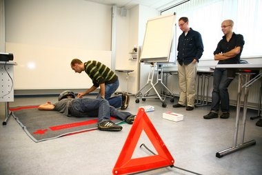 Erste Hilfe Kursteilnehmer üben die Helmabnahme bei Unfällen