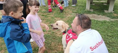 2 Kinder treffen einen Suchhund