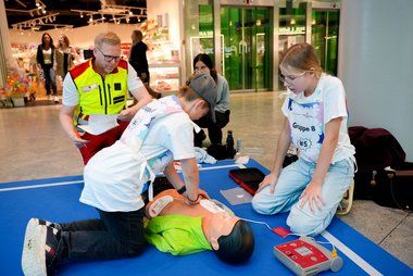 Schüler:innen üben die Wiederbelebung an einer Puppe