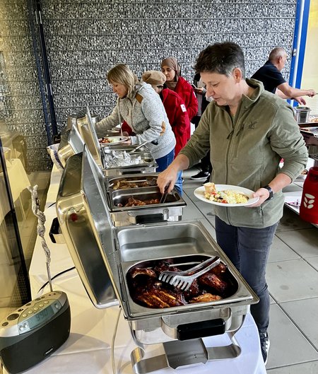 Mitarbeiter:innen des Seniorenwohnhauses Hallein holen sich Essen am Buffettisch