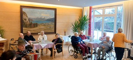 Eine Frau am Geburtstagsfest, rund um sie sieht man Ballone und Kuchen. 