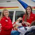 Zwei weibliche Sanitäterinnen vor einem Rettungsauto wie sie einen Patienten betreuen.