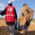 Rotkreuzmitarbeiterin hilft Person in Somalia dabei, Wasser zu tragen
