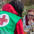 Eine Mitarbeiterin der Krisenintervention spricht mit einer Frau, die in einer Rettungsdecke eingewickelt ist. Sie bekommt psychosoziale Unterstützung während einer Krise