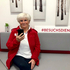 Besuchsdienst-Mitarbeiterin sitzt mit dem Handy in der Hand